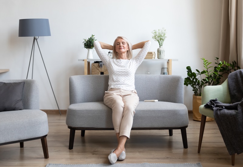 Relaxed,Satisfied,Older,Woman,Sitting,Leaning,Back,On,Couch,In